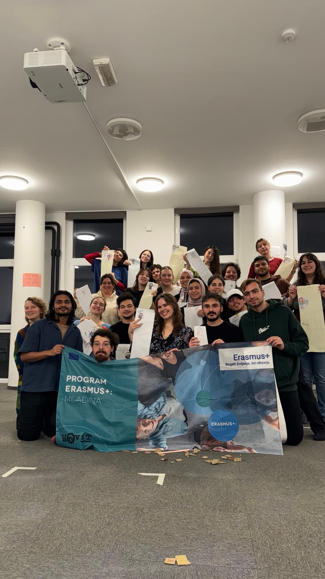Gruppo di partecipanti a un evento Erasmus+ con il banner ufficiale del programma